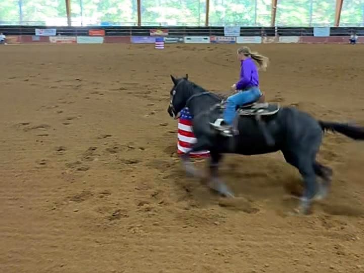 Adeline Frost turning a barrel on Blackie, a black horse, at the NBHA Louisiana State Championships in Ruston