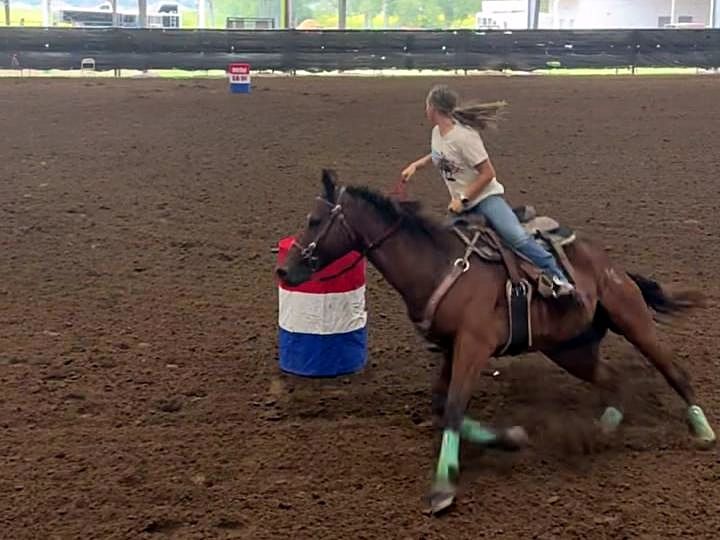 Adeline Frost rounding a barrel on Ditto, a bay horse
