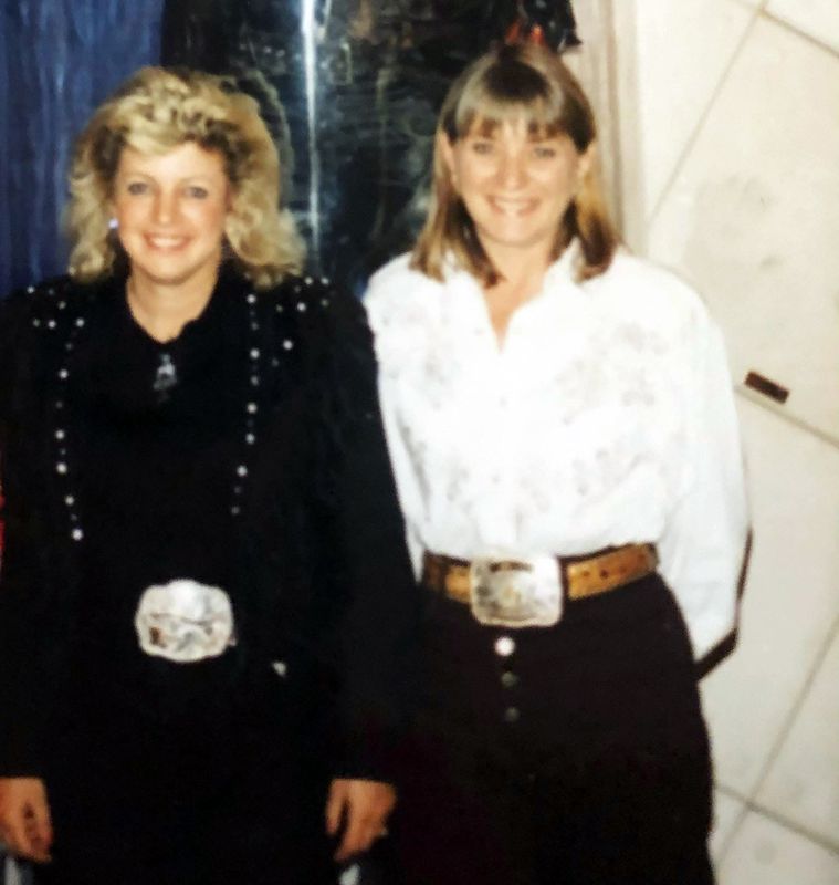 Merrill O'Neal in a black jacket and Merrill G. Frost in a white blouse, each wearing a trophy buckle